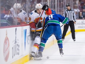 Calgary Flames' Dmitry Zavgorodniy, left, of Russia, is checked by Vancouver Canucks' Brendan Leipsic during the first period of a pre-season NHL hockey game in Vancouver, B.C., on Wednesday September 19, 2018. THE CANADIAN PRESS/Darryl Dyck ORG XMIT: VCRD108