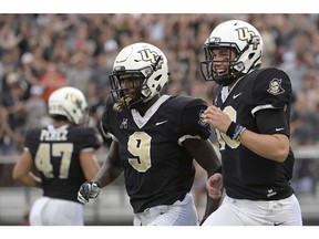 Central Florida running back Adrian Killins Jr. (9) and quarterback McKenzie Milton (10) celebrate after Killins rushed for a 24-yard touchdown during the first half of an NCAA college football game against South Carolina State Saturday, Sept. 8, 2018, in Orlando, Fla.