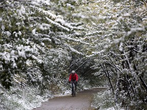 A cyclist makes their way along a snow-lined bike path in Edmonton on Thursday, Sept. 13, 2018.