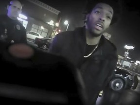 This Jan. 26, 2018 police body-camera footage released by Milwaukee Police Department shows Bucks guard Sterling Brown as he talks to arresting police officers after being shot by a stun gun in a Walgreens parking lot in Milwaukee. (Milwaukee Police Department via AP)