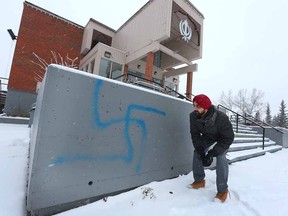 Volunteer Harpeet Singh Gill examines graffiti outside the Sikh Society temple in southwest Calgary on Dec. 23, 2016. The temple has been a frequent target of vandals.