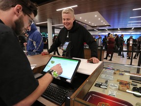Liam, who waited 12 hours in line, Makes a purchase at Nova Cannabis in Calgary, on Wednesday October 17, 2018. Leah Hennel/Postmedia