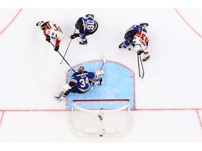 ST. LOUIS, MO - OCTOBER 11: Alex Pietrangelo #27, Ryan O'Reilly #90 and Jake Allen #34 of the St. Louis Blues defend the goal against Mikael Backlund #11 and Sam Bennett #93 of the Calgary Flames at the Enterprise Center on October 11, 2018 in St. Louis, Missouri.