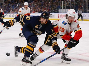 Dillon Dube #29 of the Calgary Flames knocks the puck away from Patrik Berglund #10 of the Buffalo Sabres during the second period at the KeyBank Center on October 30, 2018 in Buffalo, New York.