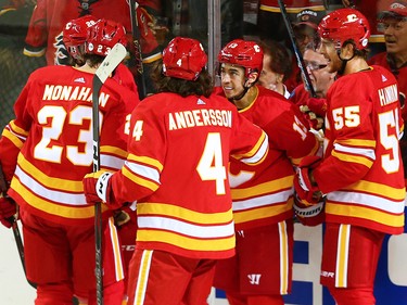 The Calgary Flames celebrate with Johnny Gaudreau after his career 100th goal during NHL action against the Boston Bruins at the Scotiabank Saddledome in Calgary on Wednesday October 17, 2018.