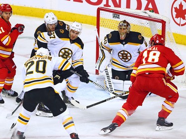 The Calgary Flames Mikael Backlund and James Neal work around Boston Bruins defenders and goaltender Tuukka Rask during NHL second period action  at the Scotiabank Saddledome in Calgary on Wednesday October 17, 2018.