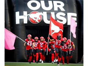 Calgary Stampeders team charges onto the field before facing the BC Lions on Oct. 13, 2018.