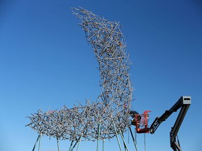 Workers install public artwork Ascend on the hill east of the Shane Homes YMCA at Rocky Ridge on Monday, Oct. 29, 2018.