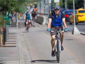 Cyclists ride the 12th Avenue bike lane in Calgary's beltline on June 27, 2018.