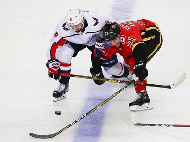 The Washington Capitals' Michal Kempny and the Calgary Flames' Garnet Hathaway scramble for the puck during NHL action at the Scotiabank Saddledome in Calgary on Saturday October 27, 2018. The Capitals won the game 4-3.