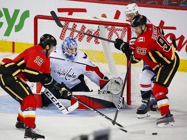 The Calgary Flames' James Neal and Sam Bennett scramble in front of Washington Capitals goaltender Pheonix Copley during NHL action at the Scotiabank Saddledome in Calgary on Saturday October 27, 2018.