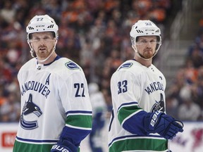 Vancouver Canucks' Daniel Sedin (22) and Henrik Sedin (33) skate past each other during first period NHL action against the Edmonton Oilers, in Edmonton on Saturday, April 7, 2018.