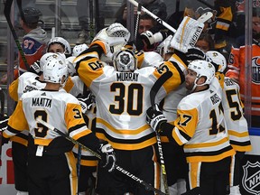 Pittsburgh Penguins Sidney Crosby is mobbed by his teammates after scoring in overtime against the Edmonton Oilers on Oct. 23, 2018.