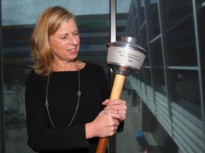Mary Moran, CEO of Calgary 2026, holds a 1988 Olympic Torch during the Celebration of Sport 2018 held at Winsport in Calgary on Thursday, October 11, 2018. Moran spoke about the benefits of hosting the 2026 Olympic games to the crowd of sport supporters and sponsors. Jim Wells/Postmedia