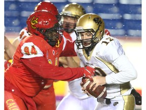 Dinos #94 Chizmy Tasie sacks Bisons QB #12 Des Catellier during U Sports Canadian college football action between the University of Calgary Dinos and the Manitoba Bisons in Calgary on Friday, October 12, 2018. Jim Wells/Postmedia