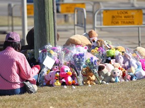 Jennifer Hung meditates at the scene on Tuesday, October 16, 2018 where a young girl was struck and killed by a CTrain on Monday morning. She also placed a small stuffed animal and a card for the family. Hung said she could feel the girl's spirit at the scene as he used the Heart Sutra. Jim Wells/Postmedia