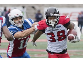 Montreal Alouettes' Chip Cox, left, tackles Calgary Stampeders' Terry Williams during first half CFL football action in Montreal, Monday.
