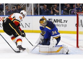 St. Louis Blues goaltender Jake Allen, right, makes a save on a shot by Calgary Flames' James Neal during the first period of an NHL hockey game Thursday, Oct. 11, 2018, in St. Louis.