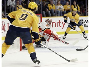 Calgary Flames goaltender Mike Smith (41) deflects a pass between Nashville Predators' Filip Forsberg (9), of Sweden, and Kevin Fiala (22), of Switzerland, in the second period of an NHL hockey game Tuesday, Oct. 9, 2018, in Nashville, Tenn.