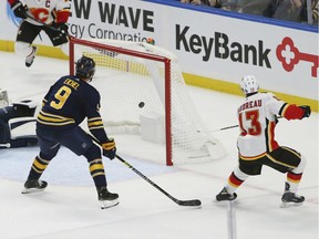 Calgary Flames forward Johnny Gaudreau puts the puck past Buffalo Sabres goalie Carter Hutton during the overtime period on Tuesday, Oct. 30, 2018, in Buffalo, N.Y.