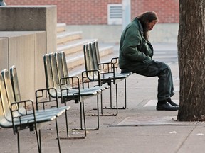 A homeless man rests on a bench outside City Hall on Nov. 22, 2016.
