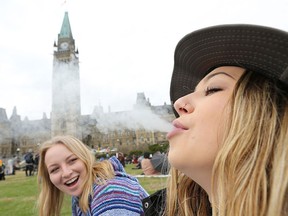 Two women smoke weed on Parliament Hill on 4/20 in Ottawa, Ontario, April 20, 2017.