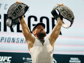 Conor McGregor holds up belts during a news conference for the UFC 229 mixed martial arts bouts Thursday, Oct. 4, 2018, in Las Vegas.