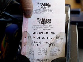 Mega Millions lottery tickets are printed out of a lottery machine at a convenience store Wednesday, Oct. 17, 2018, in Chicago.