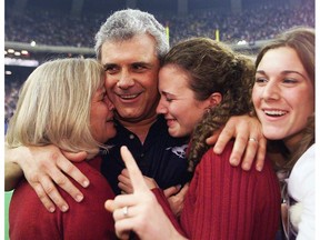 MONTREAL, NOV 25/01-Calgary Stampeders Wally Buono is hugged by his wife Sande (left) & daughters Dana and Christie (right) after winning the 2001 Grey Cup.  PHOTO AL MCINNIS/SPORTS