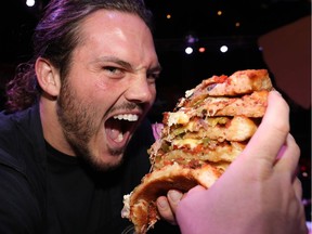 Calgary Stampeders Alex Singleton feasts during The 16th Annual 2018 Eric Francis Pizza Pigout in support of KidSport CalgaryYou Can Play and Kids Cancer Care Foundation of Alberta at Cowby's Dance Hall in Calgary on Thursday October 18, 2018. Darren Makowichuk/Postmedia