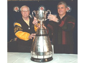 Ron Lancaster of Hamilton and Wally Buono of the Calgary Stampeders pose with the Grey Cup.