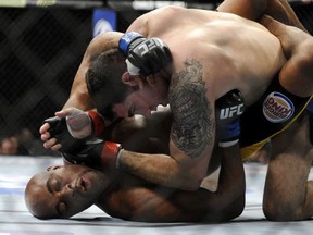 Chris Weidman, top, of Baldwin, N.Y., punches Anderson Silva, of Brazil, during the UFC 168 mixed martial arts middleweight championship bout at the MGM Grand Garden Arena, Saturday, Dec. 28, 2013, in Las Vegas. (David Becker/AP)