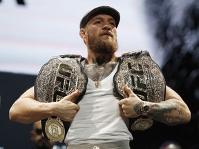Conor McGregor holds up belts during a news conference for the UFC 229 mixed martial arts bouts Thursday, Oct. 4, 2018, in Las Vegas. McGregor is scheduled to fight Khabib Nurmagomedov Saturday in Las Vegas.