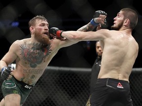 Conor McGregor, left, and Khabib Nurmagomedov throw punches during a lightweight title mixed martial arts bout at UFC 229 in Las Vegas, Saturday, Oct. 6, 2018.
