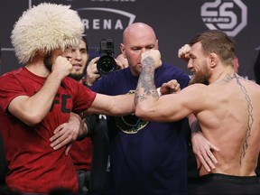 Conor McGregor, right, and Khabib Nurmagomedov face off during a ceremonial weigh-in for the UFC 229 mixed martial arts fight Friday, Oct. 5, 2018, in Las Vegas. (AP Photo/John Locher) ORG XMIT: NVJL107