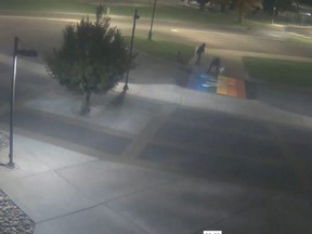 Screen grab of a pair of vandals who poured white paint over Medicine Hat College's rainbow crosswalk.