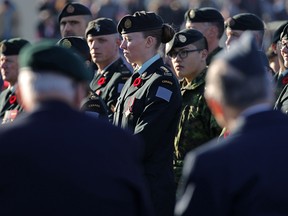 Veterans in the foreground and current armed forces members pay their respects at the cenotaph during Remembrance Day ceremonies at the Military Museums in Calgary on  Nov. 11, 2017.