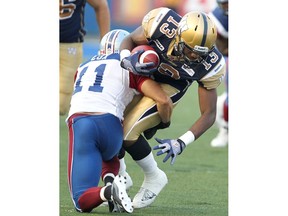 Winnipeg Blue Bombers wide receiver Chris Matthews (r) is stopped by Montreal Alouettes linebacker Chip Cox during CFL football in Winnipeg Friday August 03, 2012. BRIAN DONOGH/WINNIPEG SUN/QMI AGENCY