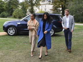 Meghan, the Duchess of Sussex, centre, accompanied by Britain's Prince Harry, the Duke of Sussex and her mother Doria Ragland walk to attend a reception at Kensington Palace, in London, Thursday Sept. 20, 2018.