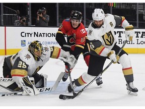 Deryk Engelland #5 of the Vegas Golden Knights clears the puck from in front of the net as goalie Marc-Andre Fleury defends against Matthew Tkachuk #19 of the Calgary Flames in the first period of their game at T-Mobile Arena on Friday in Las Vegas.