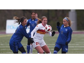 Rose-Marie Julien (left) and Karine Lafontaine (right) of the University of Montreal Carabins battle for  the ball against Maya Ida of the Calgary Dinos during action of the Canadian university women's soccer championships on Friday.     Photo by Jean Levac/Postmedia.