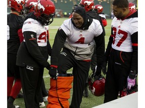 The Calgary Stampeders' Micah Johnson (4) steps into a heating vent to warm up his leg during a team practice at Commonwealth Stadium, in Edmonton Friday. The Stampeders will face the Ottawa Redblacks in the Grey Cup this Sunday. Photo by David Bloom/Postmedia.