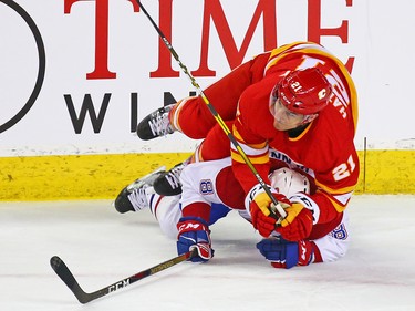 The Calgary Flames' Garnet Hathaway lands on top of the Montreal Canadiens' Jordie Benn during NHL action at the Scotiabank Saddledome in Calgary on Thursday November 15, 2018.