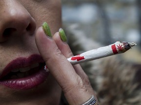 Krissy Calkins smokes a marijuana joint at a "Wake and Bake" legalized marijuana event in Toronto on Wednesday, October 17, 2018.