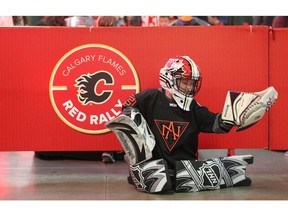 Dominic Karkkainen, 8 yrs, from the Midnapore Mavericks Novice 2 team, practices his best goaltending moves on the concourse during the Calgary Flames Red Rally for fans at the Saddledome in Calgary on Sunday, November 4, 2018. The family event allowed fans to watch an open practice, get autographs from some current and alumni players and games on the concourse. Jim Wells/Postmedia