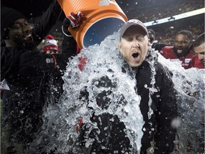 Calgary Stampeders head coach Dave Dickenson gets the water bucket dumped on him after his team defeated the Ottawa Redblacks in the 106th Grey Cup in Edmonton, Alta. Sunday, Nov. 25, 2018.