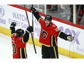 Calgary Flames defenseman Noah Hanifin (55) celebrates his goal against the Arizona Coyotes with center Derek Ryan (10) during the second period of an NHL hockey game Sunday, Nov. 25, 2018, in Glendale, Ariz. The Flames defeated the Coyotes 6-1.