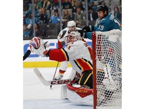 Calgary Flames goaltender Mike Smith (41) makes a save against San Jose Sharks' Joe Thornton (19) in the second period of an NHL hockey game in San Jose, Calif., Sunday, Nov. 11, 2018.