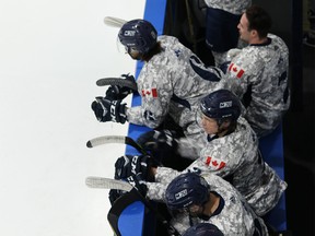 The Mount Royal Cougars salute the Canadian military Friday night at Flames Community Arenas.