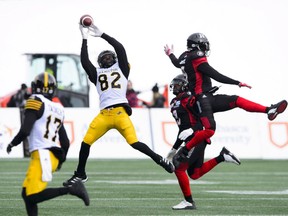 Hamilton Tiger-Cats' Justin Buren (82) makes a catch as Ottawa Redblacks' Jonathan Rose (9), right, jumps during first half CFL East Division final action in Ottawa on Sunday, Nov. 18, 2018. THE CANADIAN PRESS/Sean Kilpatrick